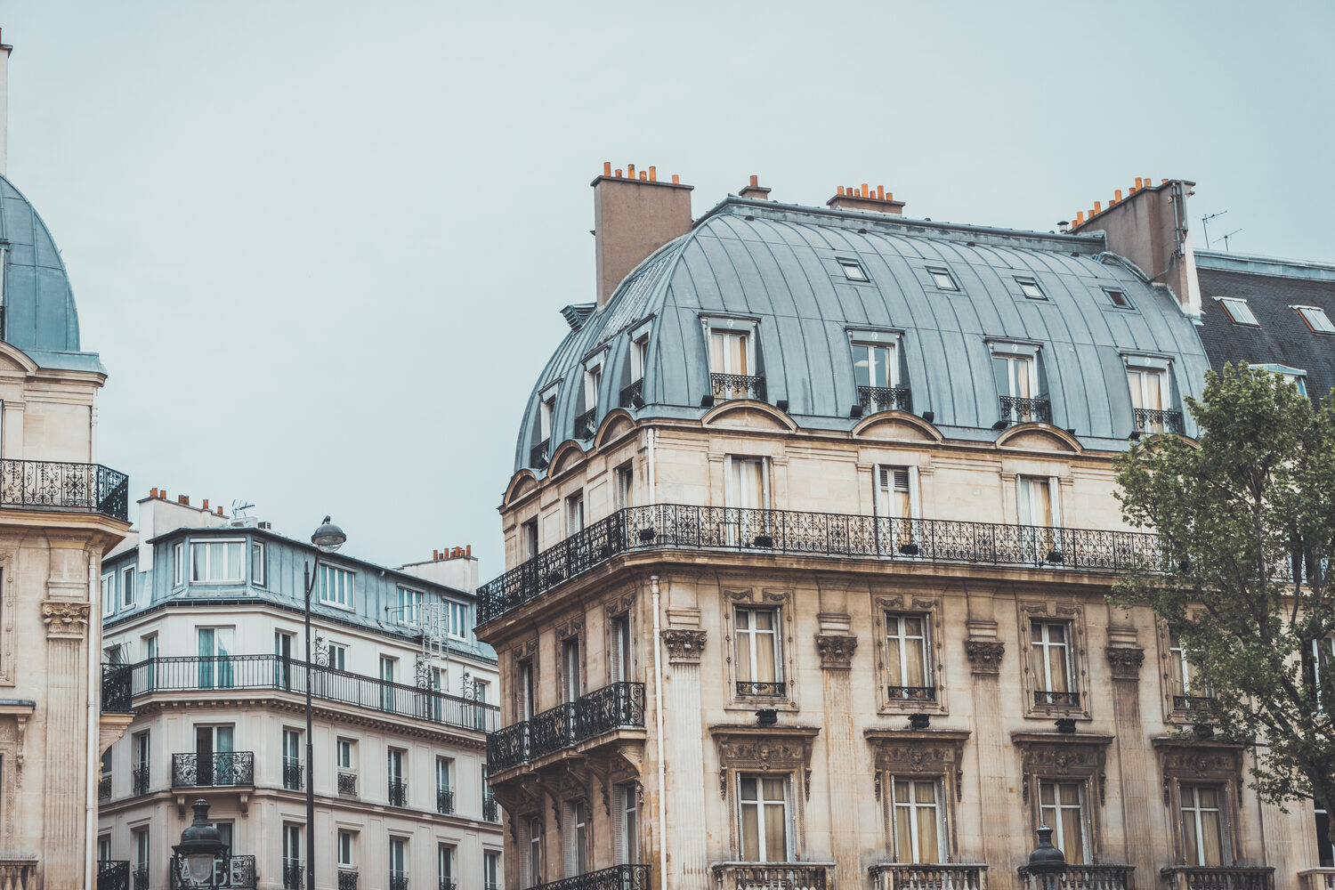 Rua de paralelepípedos em Montmartre na hora azul, com a cúpula do Sacré-Cœur ao fundo.